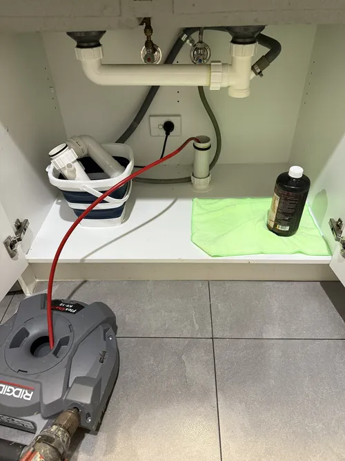 plumber fixing a blocked sink in brisbane