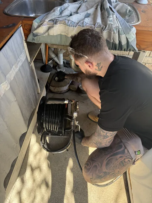 draintech team jet blasting a drain at a brisbane home